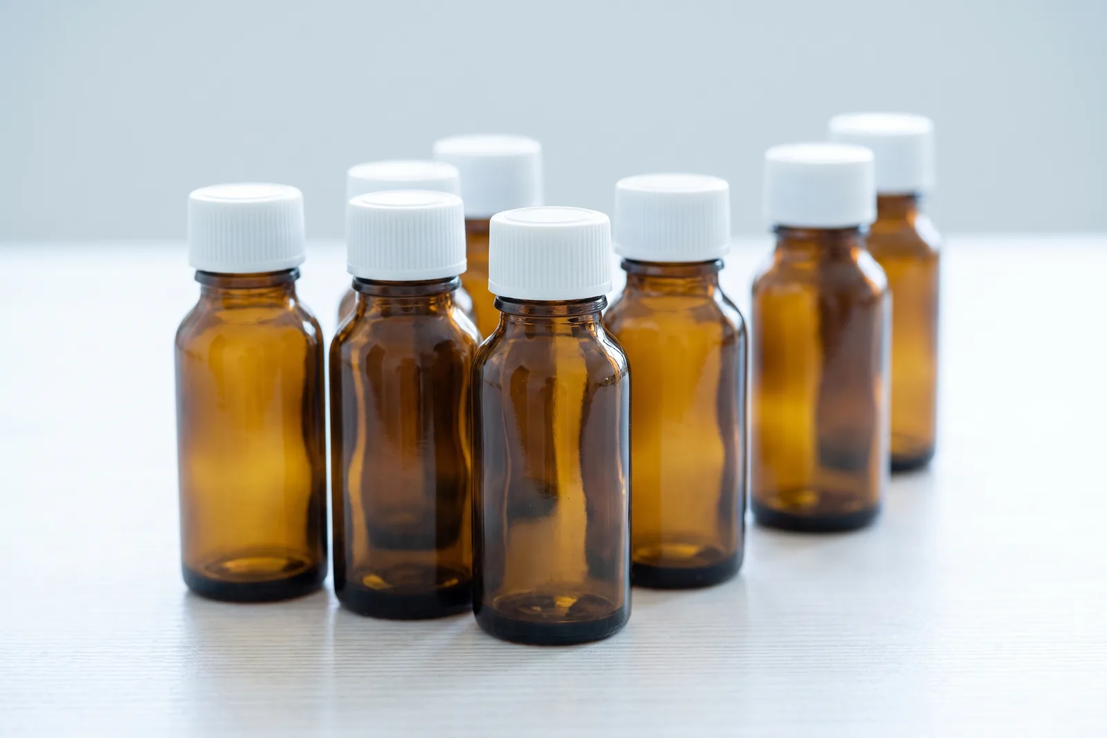 A group of amber medicine bottles with plain white caps